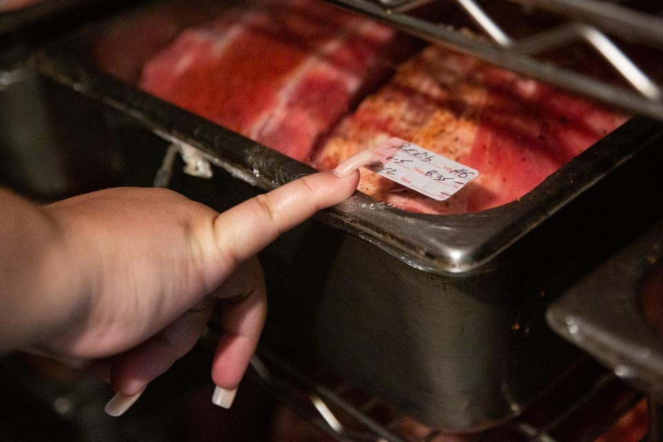 Joanie Garza, a public health inspector with the city, checks the dates and labeling on storage containers in a walk-in refrigerator during a restaurant inspection on June, 6 2023, in Corpus Christi, Texas.