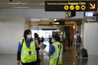 A pair of workers at Seattle-Tacoma International Airport wear masks Tuesday, March 3, 2020, in SeaTac, Wash. Six of the 18 Western Washington residents with the coronavirus have died as health officials rush to test more suspected cases and communities brace for spread of the disease. All confirmed cases of the virus in Washington are in Snohomish and King counties. (AP Photo/Elaine Thompson)