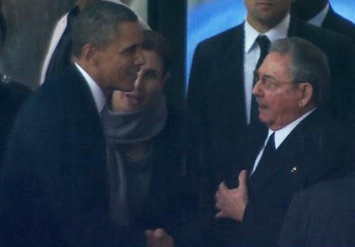 Un vídeo capta el apretón de manos entre los presidentes de EEUU, Barack Obama (i), y de Cuba, Raúl Castro, el 10 de diciembre de 2013 en el homenaje a Nelson Mandela en Johannesburgo (Sabc/AFP | -)