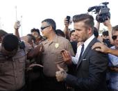 David Beckham makes his way through a crowd while visiting the Kendall Soccer Park in suburban Miami February 5, 2014. REUTERS/Andrew Innerarity