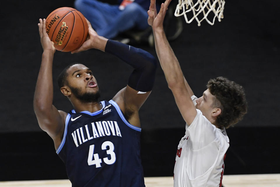 Villanova's Eric Dixon, left, shoots over Hartford's Hunter Marks in the first half of an NCAA college basketball game, Tuesday, Dec. 1, 2020, in Uncasville, Conn. (AP Photo/Jessica Hill)