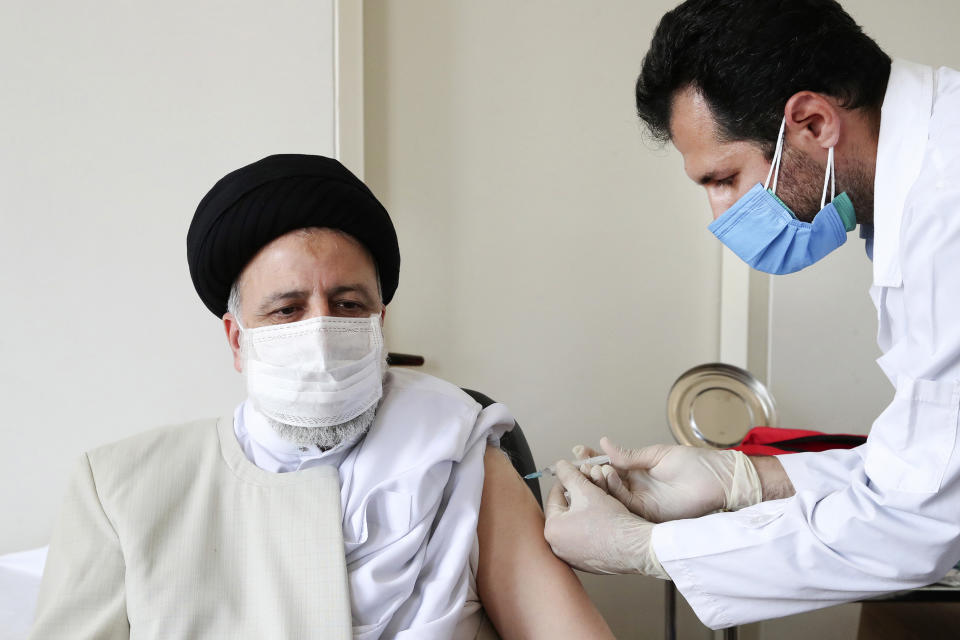 In this photo released by the official website of the office of the Iranian Presidency, President Ebrahim Raisi receives his first shot of the Covid-19 COVIran Barekat vaccine, in Tehran, Iran, Sunday, Aug. 8, 2021. On Sunday, Iran reported more new infections and deaths across the country than on any other single day since the pandemic began. In the face of U.S. sanctions that complicate banking transactions and deep-rooted suspicion of the West, Iran has vigorously promoted the local production of coronavirus vaccines, doling out the experimental COVIran Barekat vaccine to most healthcare workers. (Iranian Presidency Office via AP)