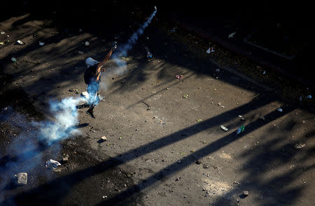 A demonstrator throws back a tear gas canister during clashes with security forces following a rally against the government of Venezuela's President Nicolas Maduro and to commemorate May Day in Caracas Venezuela, May 1, 2019. REUTERS/Adriana Loureiro