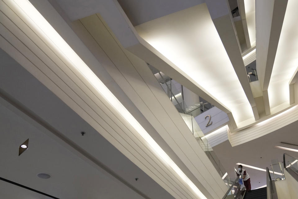 A worker cleans an escalator during the opening at the Paragon shopping mall in Bangkok, Thailand, Wednesday, Sept. 1, 2021. Thailand to ease business lockdown measures in the capital and provinces where restrictions have been implemented since mid-July. Malls, hair salons, foot massage parlors, and parks will be allowed to re-open, as well as restaurants for dine-in services but maintained at 50% capacity. (AP Photo/Sakchai Lalit)