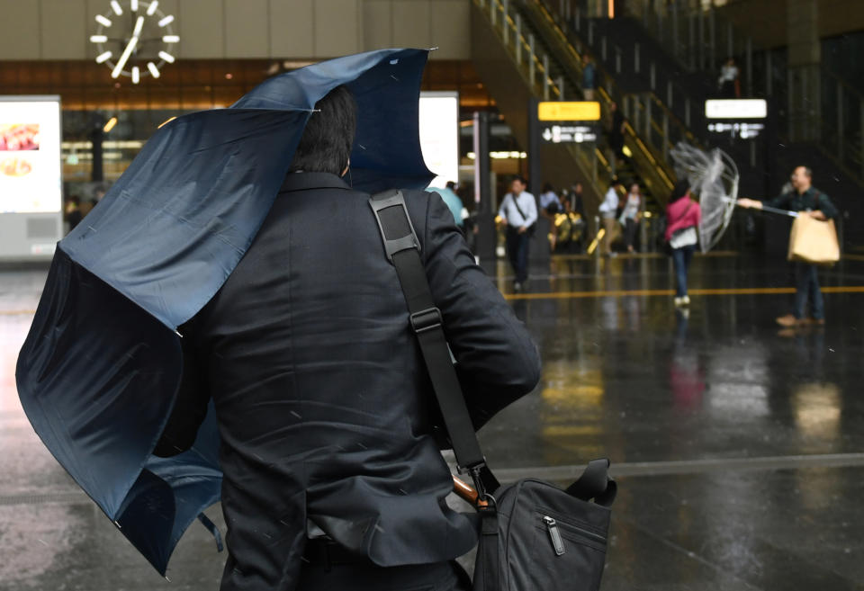 A man walks in the rain close to Osaka Station as Typhoon Hagibis approaches Osaka, Japan, October 12, 2019. REUTERS/Annegret Hilse