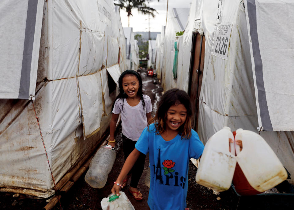 Girls carry water containers to be filled at an evacuation camp for families displaced by the Marawi siege, in Marawi City, Lanao del Sur province, Philippines. (Photo: Eloisa Lopez/Reuters)