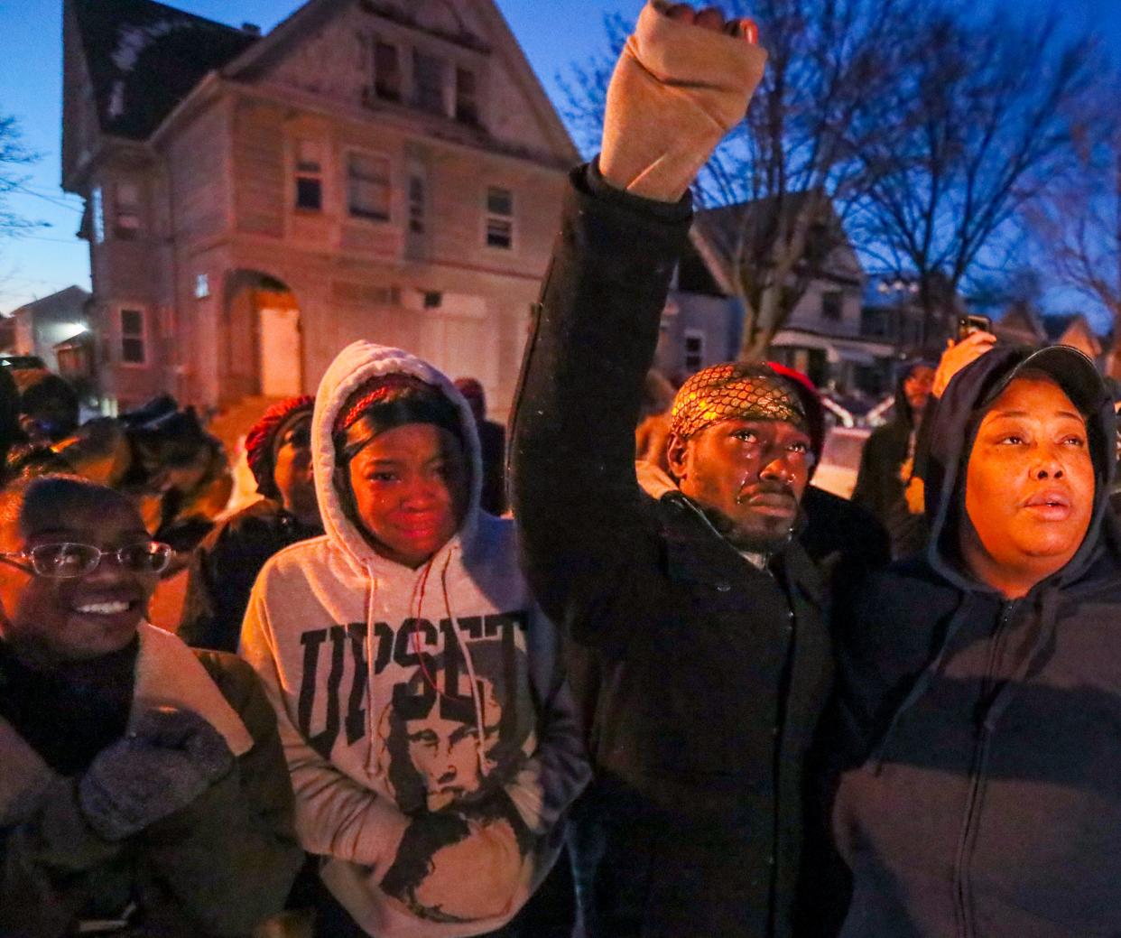 Family, friends and community members surround Kuamaine Harris, the son of Michelle Williams, who was one of six homicide victims found Sunday in a duplex near 21st and Wright Streets in Milwaukee. They are watching the balloons float into the sky.