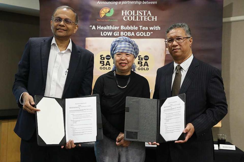 Holista CEO Datuk Dr Rajen Manicka and Fruit Hub chairman Mohamed Zainurin Mohamed Zain exchanging joint collaboration documents. Looking on is SunFresh managing director Foong Wai Fong. — Picture by Mohd Yusof Mat Isa