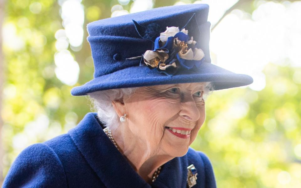 The Queen wore a deep blue dress and a matching hat with blue and white flowers - Samir Hussein/WireImage