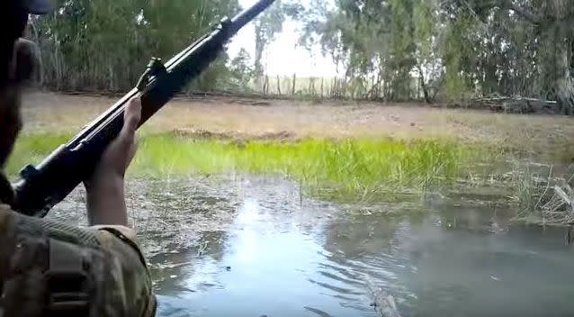 Pig hunters trying to cross a creek have had to run and shoot at the water when a crocodile charged. Photo: Liveleak