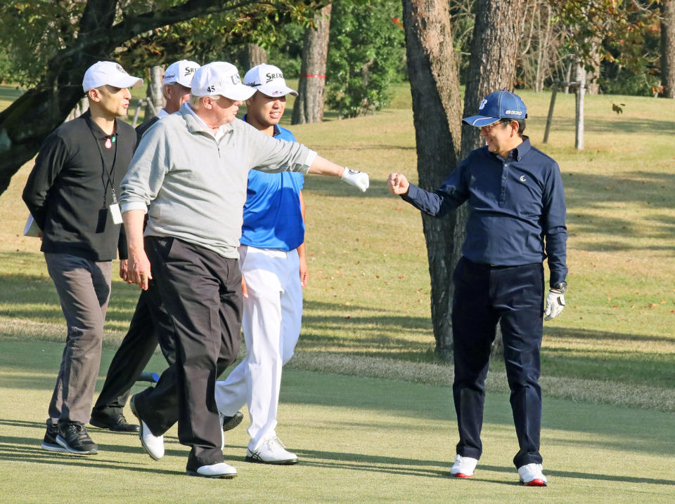 President Donald Trump gestures to Japan's Prime Minister Shinzo Abe as Japanese professional golfer Hideki Matsuyama looks on, as they play golf at the Kasumigaseki Country Club in Kawagoe, north of Tokyo, Japan.