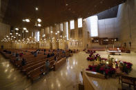 FILE - In this Thursday, Dec 24, 2020, file photo, worshippers gather for Christmas Eve Mass at the Cathedral of Our Lady of the Angels in Los Angeles. Parishes, schools and ministries in Los Angeles collected at least $80 million in paycheck protection aid. That came at a time when the headquarters reported over $650 million in available funds in the fiscal year when the coronavirus arrived. (AP Photo/Ashley Landis)