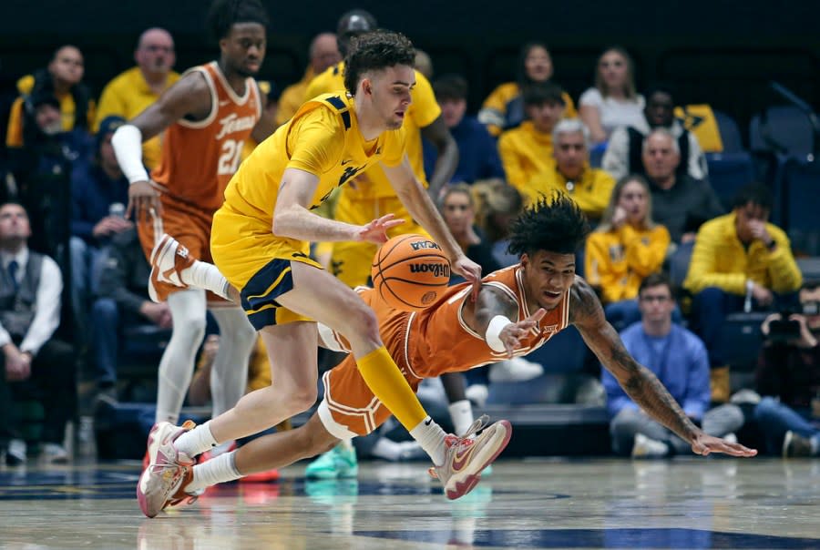 West Virginia forward Ofri Naveh (9) is defended by Texas forward Dillon Mitchell (23) during the first half of an NCAA college basketball game on Saturday, Jan. 13, 2024, in Morgantown, W.Va. (AP Photo/Kathleen Batten)