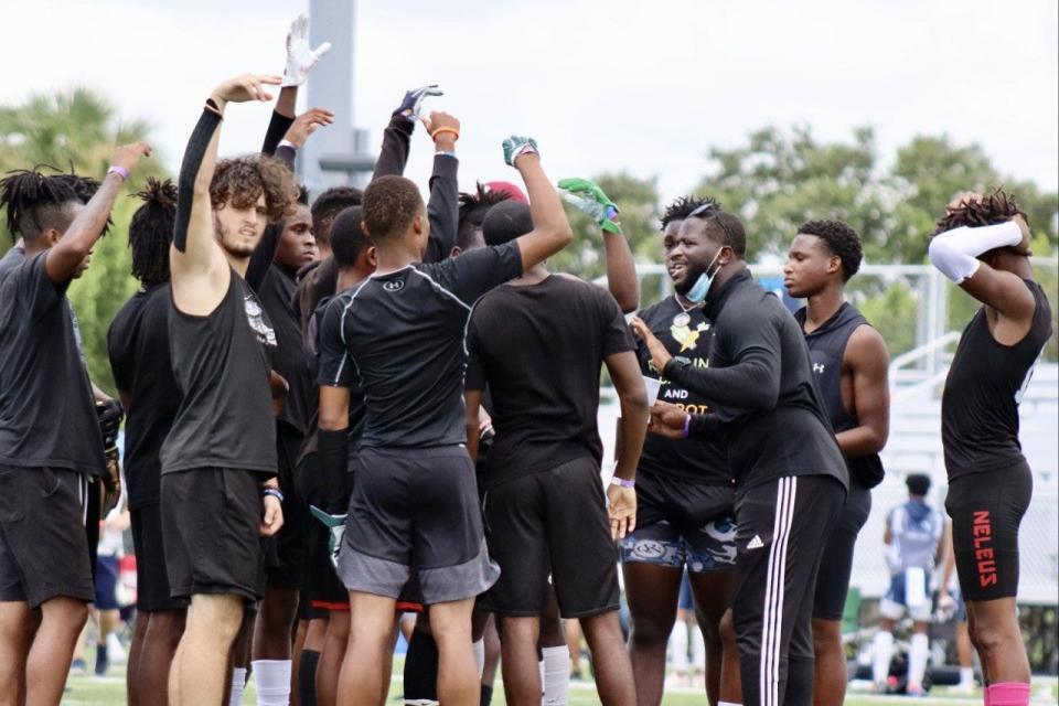 Former Detroit Lions CB turned head coach Alphonso Smith (third from right) directs the Inlet Grove Hurricanes from midfield in the 2021 preseason.