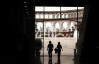 A man and a woman walk through a building that resembles a Roman Coliseum at the Florentia Village in the district of Wuqing, located on the outskirts of the city of Tianjin June 13, 2012. <br><br><a href="http://news.yahoo.com/photos/china-replicates-austrian-village-slideshow/" data-ylk="slk:Click here;elm:context_link;itc:0;sec:content-canvas;outcm:mb_qualified_link;_E:mb_qualified_link;ct:story;" class="link  yahoo-link">Click here</a> to see a related gallery: China replicates Austrian village