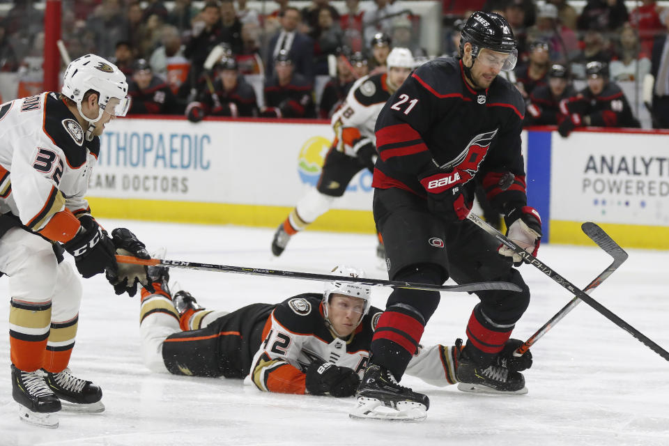 Carolina Hurricanes right wing Nino Niederreiter (21), of the Czech Republic, controls the puck while Anaheim Ducks defenseman Josh Manson (42) and defenseman Jacob Larsson (32) defend during the second period of an NHL hockey game in Raleigh, N.C., Friday, Jan. 17, 2020. (AP Photo/Gerry Broome)