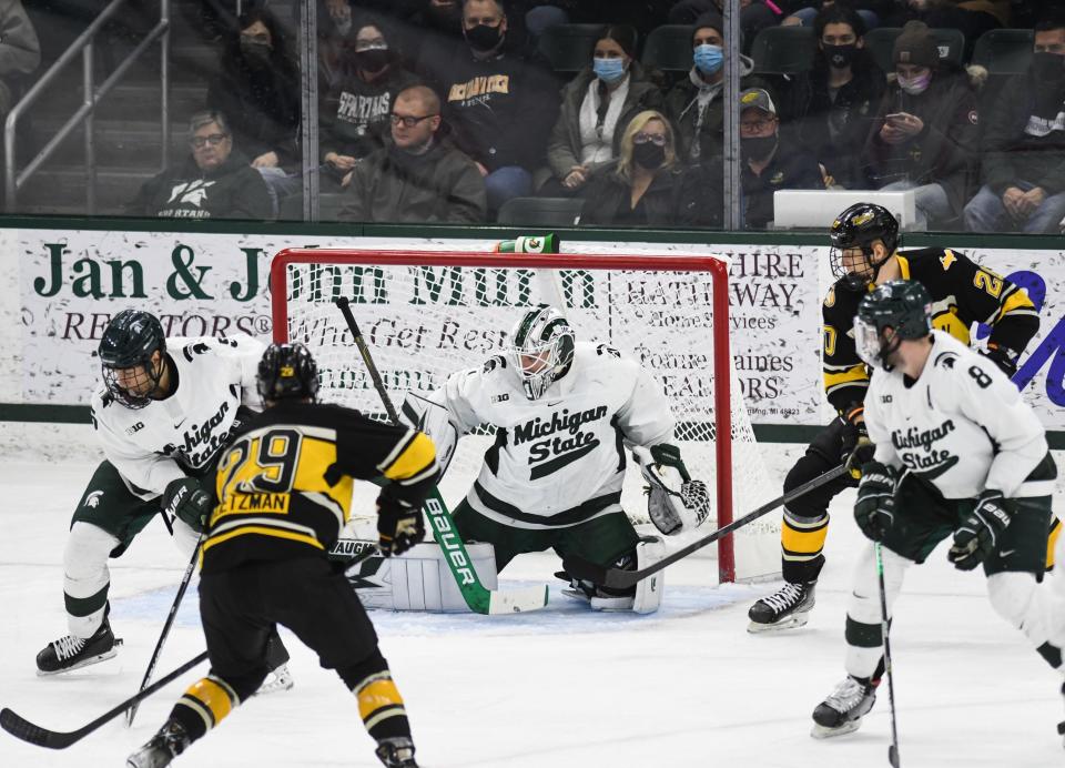 MSU goaltender Drew DeRidder, Powell Connor, left, and Cole Krygier (8) defend the net against Michigan Tech Thursday, Dec. 30, 2021, during the Great Lakes Invitational at Munn Ice Arena in East Lansing.  MSU won 3-2 in overtime.