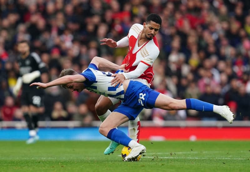 Brighton and Hove Albion's Evan Ferguson (L) and Arsenal's William Saliba battle for the ball during the English Premier League soccer match between Arsenal and Brighton at the Emirates Stadium. Nick Potts/PA Wire/dpa