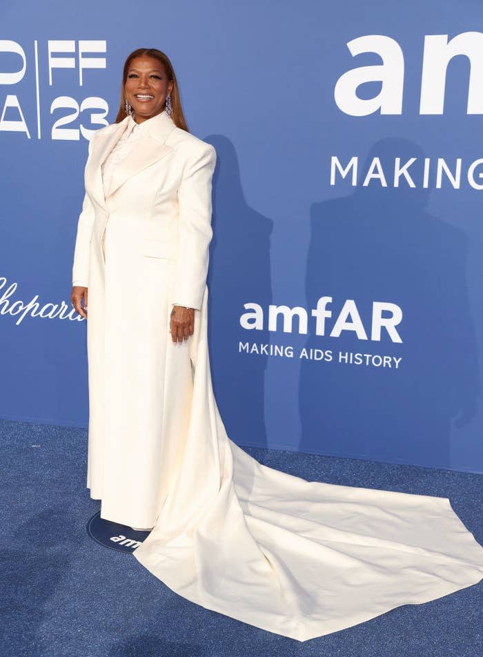 Queen Latifah is wearing a monochrome coat dress with a short train