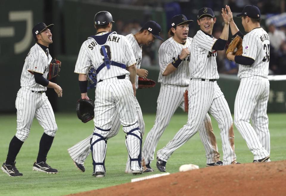 Japan's closer Kazuhisa Makita, right, and Shogo Akiyama, second from right, celebrate with teammates after beating Cuba 8-5 in their second round game at the World Baseball Classic at Tokyo Dome in Tokyo, Tuesday, March 14, 2017. (AP Photo/Toru Takahashi)