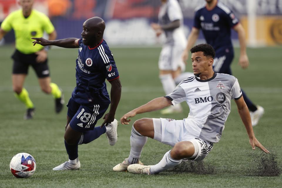 New England Revolution's Ema Boateng (18) gets past Toronto FC's Brandon Servania, right, during the first half of an MLS soccer match, Saturday, June 24, 2023, in Foxborough, Mass. (AP Photo/Michael Dwyer)