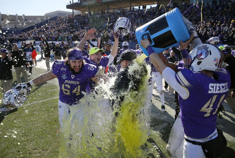 James Madison's Matt Frank (64) and Brett Siegel (41) celebrate as head coach Mike Houston, center, is dunked after their 28-14 win against Youngstown State in the FCS championship NCAA college football game, Saturday, Jan. 7, 2017, in Frisco, Texas. (AP Photo/Tony Gutierrez)