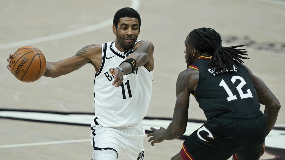 Brooklyn Nets' Kyrie Irving (11) drives past Cleveland Cavaliers' Taurean Prince (12) during double overtime of an NBA basketball game, Wednesday, Jan. 20, 2021, in Cleveland. The Cavaliers won 147-135 in double-overtime. (AP Photo/Tony Dejak)