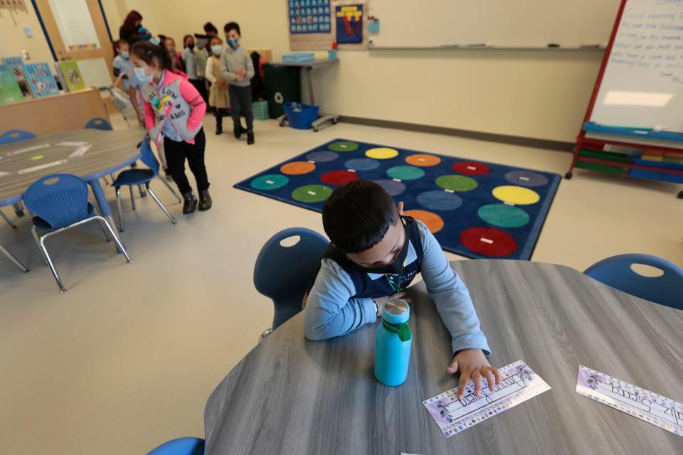 Kindergartner, Omauri Riveira reads his name after finding his spot on his desk on the first day of school at the new Alma del Mar Frederick Douglass campus on Church Street in New Bedford.