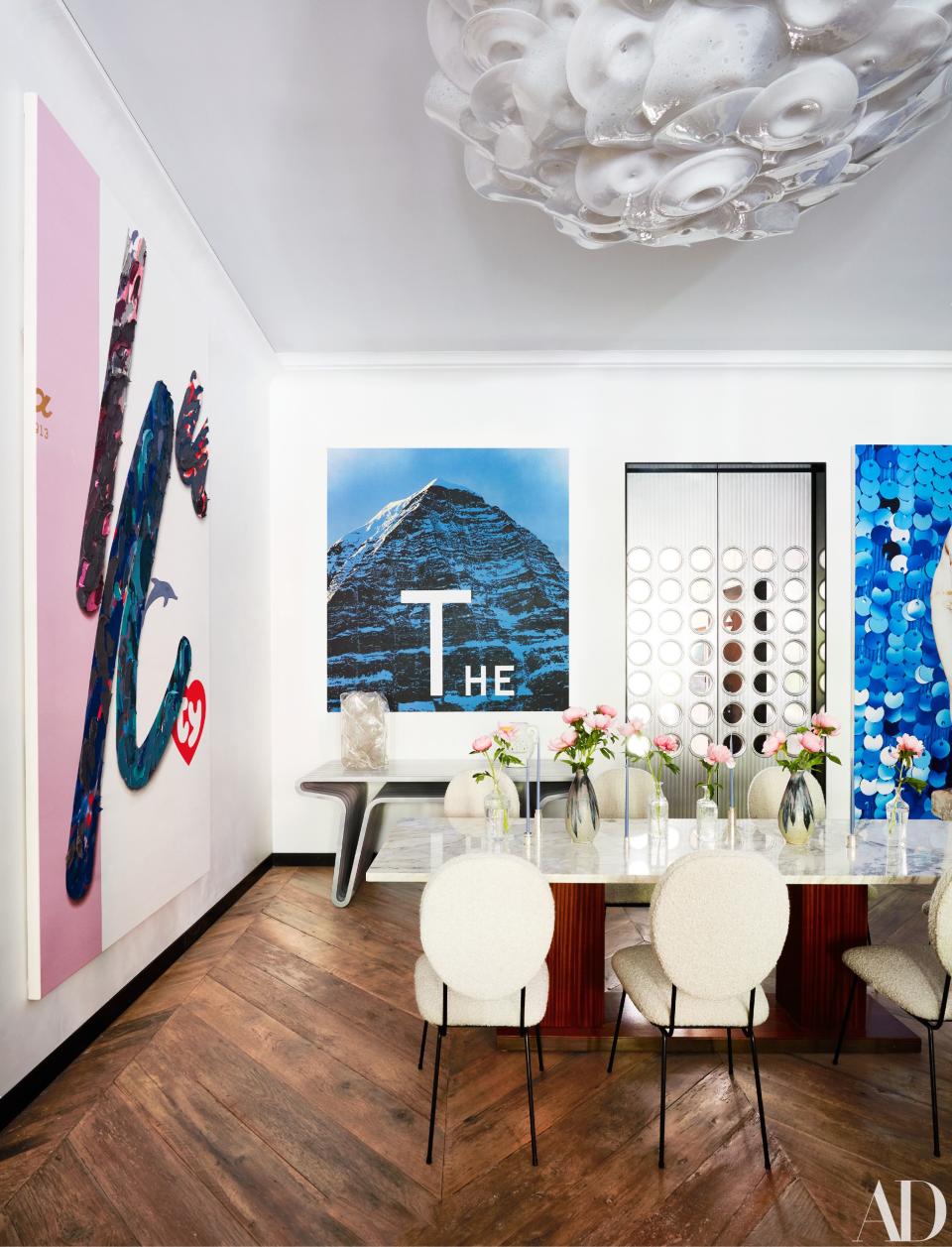 Lighting by Jeff Zimmerman hangs above the vintage Rene-Jean Caillette dining table and Joaquim Tenreiro chairs. Paintings by Laura Owens (left) and Ed Ruscha.