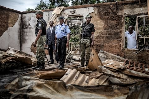 Nigerian Police Officers and Adara leaders visit and patrol an area of destroyed and burned houses after a recent Fulani attack in the Adara farmers' village of Angwan Aku - Credit: AFP