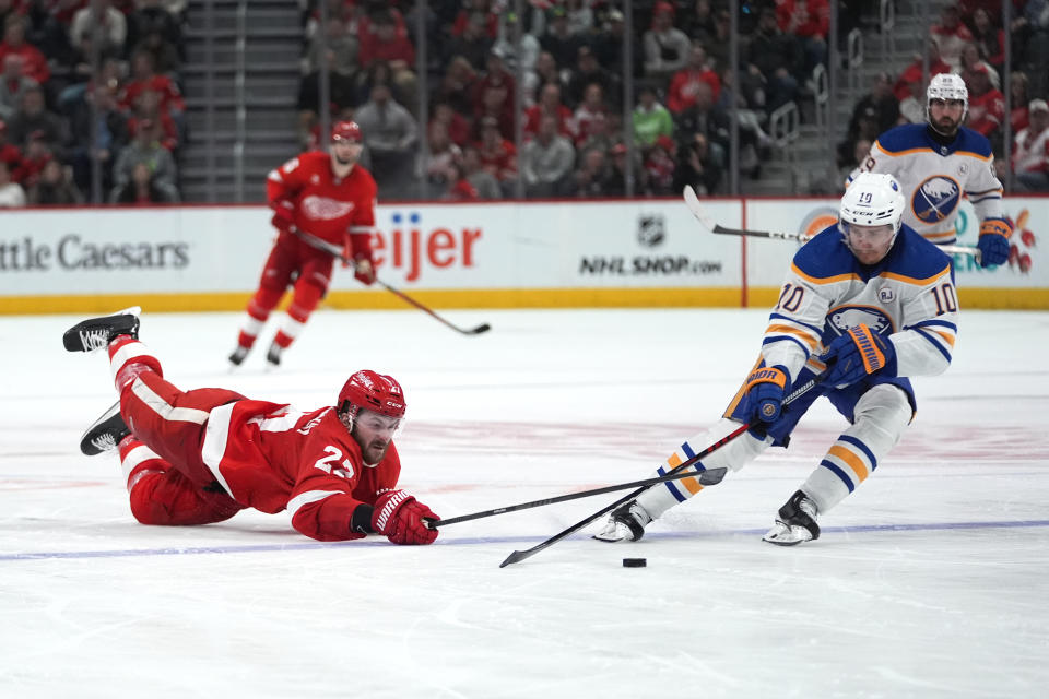 Detroit Red Wings center Michael Rasmussen (27) dives to clear the puck as Buffalo Sabres defenseman Henri Jokiharju (10) gain possession in the third period of an NHL hockey game Saturday, March 16, 2024, in Detroit. (AP Photo/Paul Sancya)