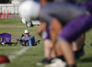 In this Aug. 5, 2019, photo, Tom Ramsay sits along the sideline and watches the team's first practice lead by new head coach Art Briles at Mount Vernon High School in Mount Vernon, Texas. (AP Photo/Tony Gutierrez)