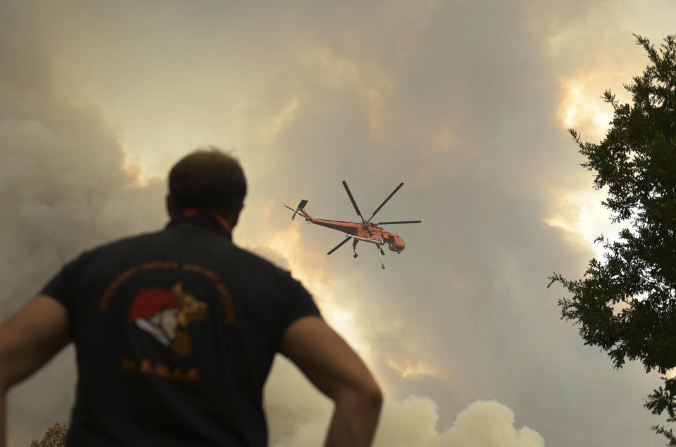 A helicopter flies over a wildfire in Giannouli village, in the northeastern Evros region, Greece, Thursday, Aug. 31, 2023. Greek authorities have further reinforced firefighting forces in the country's northeast, where a massive blaze in its thirteenth day has flared up once more, triggering authorities to issue alerts to residents in the area to be on standby for possible evacuation. (e-evros.gr via AP)