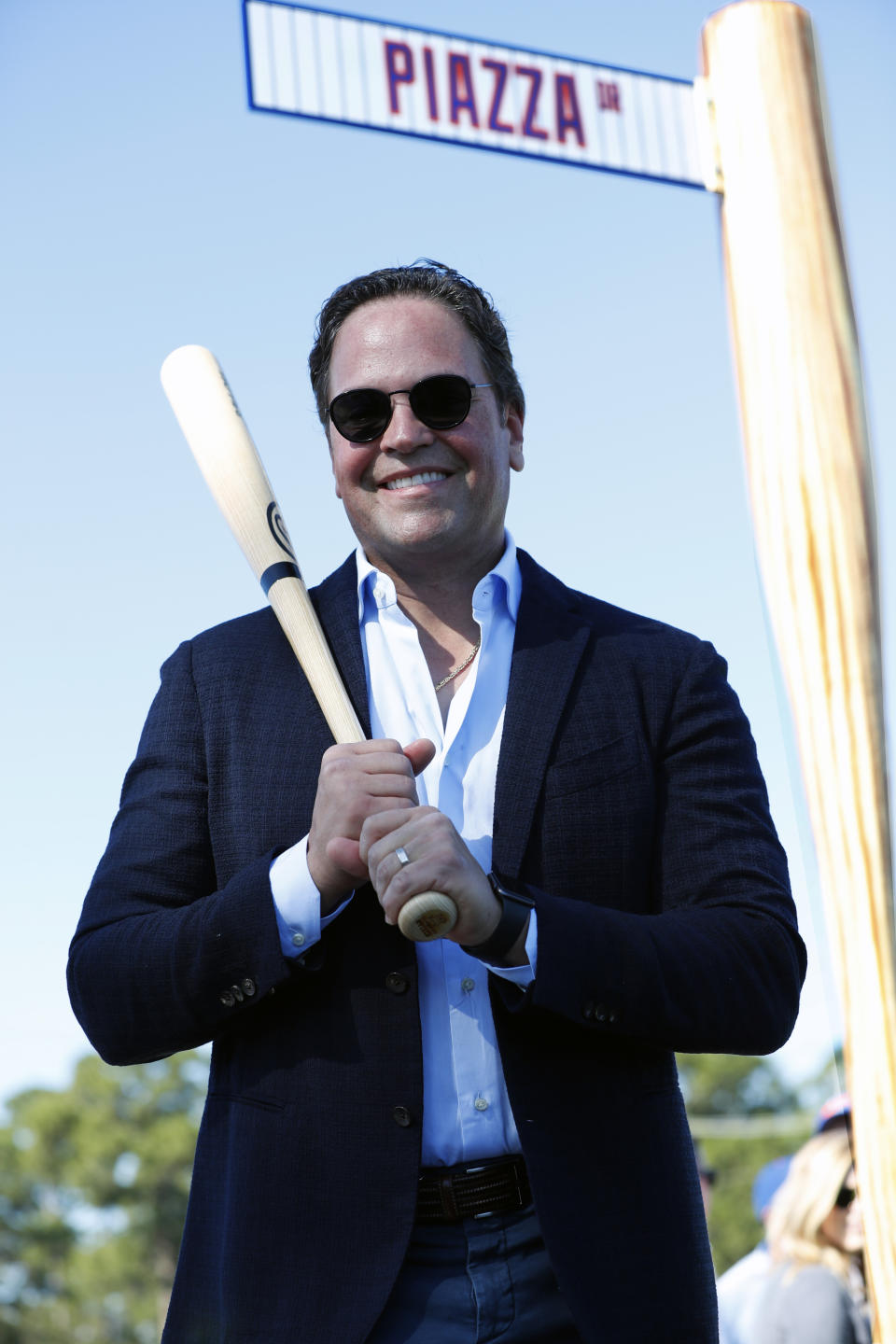 Former New York Mets catcher Mike Piazza poses for a photo under a street sign for newly named Piazza Dr., after a ceremony in front of the Mets spring training facility, Thursday, Jan. 16, 2020, in Port St. Lucie, Fla. (AP Photo/Wilfredo Lee)