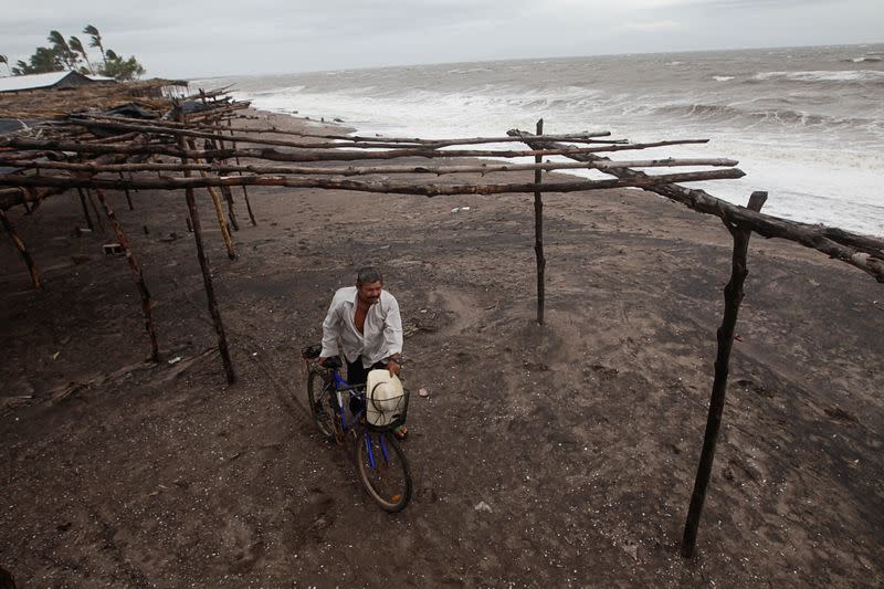 A man holds his bicycle at a beach as Storm Iota approaches, in Cedeno