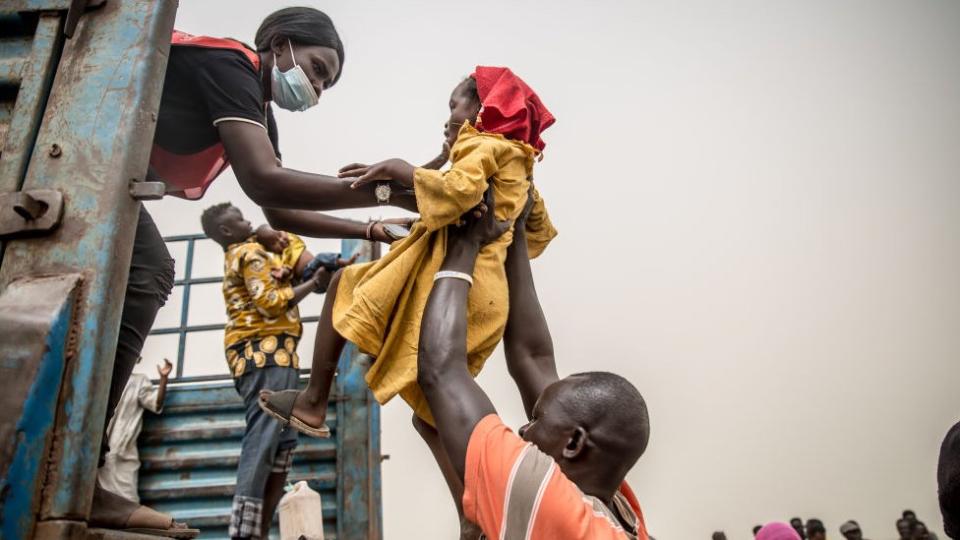 A child is loaded into a truck carrying people fleeing the war in Sudan from Joda on the Sudanese border to Renk in South Sudan