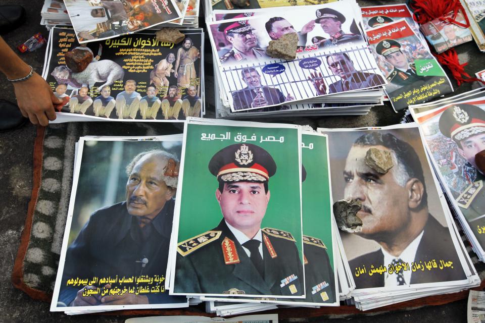 FILE - In this Thursday, Aug. 8, 2013 file photo, posters showing Egyptian Army Chief Lt. Gen. Abdel-Fattah el-Sissi with Arabic that reads, "Egypt over all," center, are displayed between posters of late Presidents Anwar Sadat, left, and Gamal Abdel Nasser, right, in Tahrir Square in Cairo, Egypt. Arabic at right reads," don't trust the Brotherhood" and at left, " I was wrong when I released the Brotherhood out of prisons." The head of Egypt’s military, Abdel-Fattah el-Sissi, is riding on a wave of popular fervor that is almost certain to carry him to election as president. Unknown only two years ago, a broad sector of Egyptians now hail him as the nation’s savior after he ousted the Islamists from power, and the state-backed personality cult around him is so eclipsing, it may be difficult to find a candidate to oppose him if he runs. Still, if he becomes president, he faces the tough job of ruling a deeply divided nation that has already turned against two leaders.(AP Photo/Amr Nabil, File)