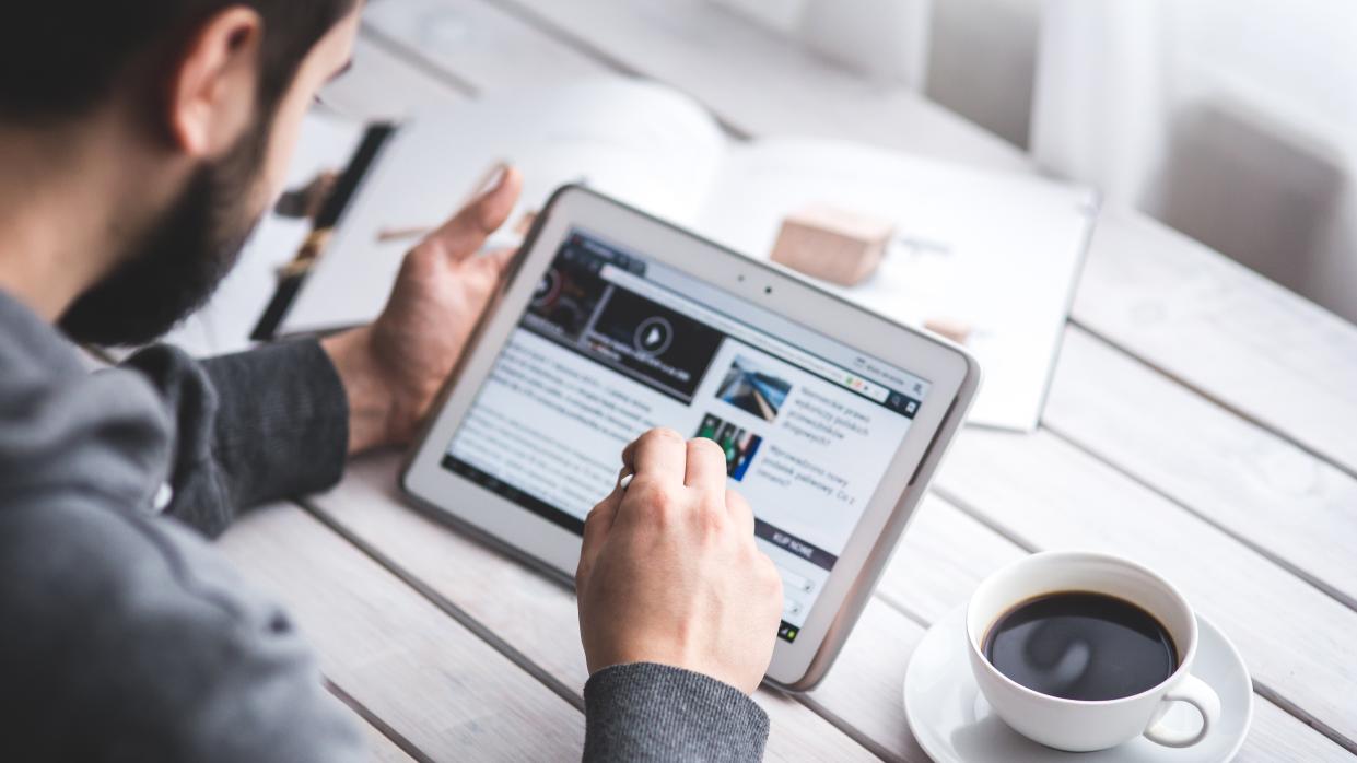  Man reading news on tablet. 