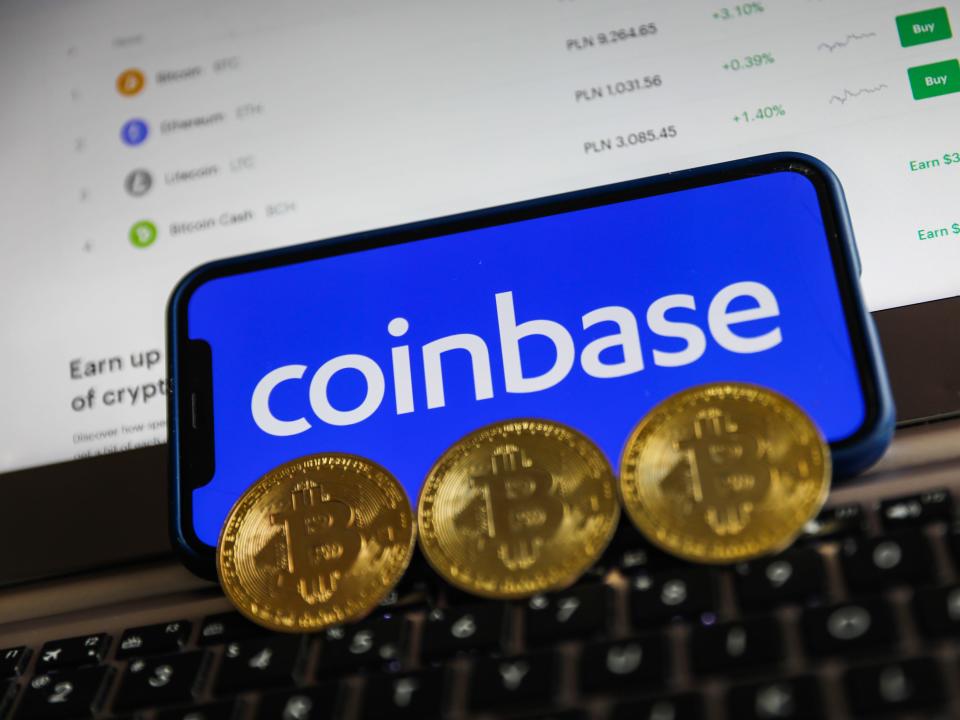 Coinbase logo displayed on a phone screen and representation of Bitcoin are seen in this illustration photo taken in Krakow, Poland on April 15, 2021