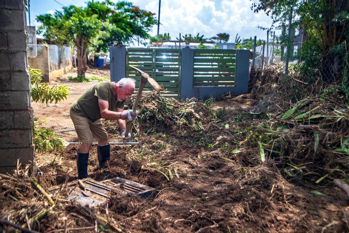 Deogracio Arce, 70, uses a pick to dig out some of his belongings that were swept away after Hurricane Fiona caused flooding in Villa Esperanza in Salinas, Puerto Rico.