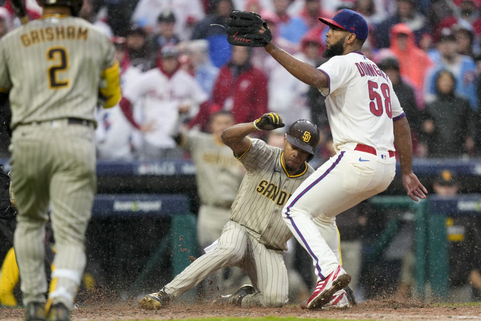 San Diego Padres' Jose Azocar scores past Philadelphia Phillies relief pitcher Seranthony Dominguez on a wild pitch during the seventh inning in Game 5 of the baseball NL Championship Series between the San Diego Padres and the Philadelphia Phillies on Sunday, Oct. 23, 2022, in Philadelphia. (AP Photo/Matt Slocum)