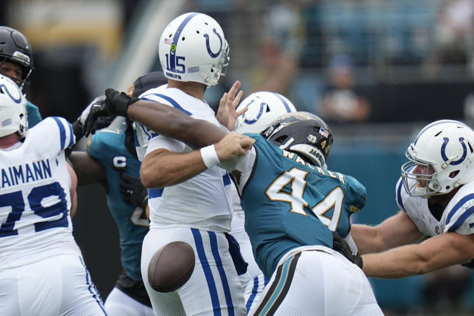 Indianapolis Colts quarterback Joe Flacco (15) fumbles as he is hit by Jacksonville Jaguars' Travon Walker (44) during the first half of an NFL football game, Sunday, Oct. 6, 2024, in Jacksonville, Fla. (AP Photo/John Raoux)