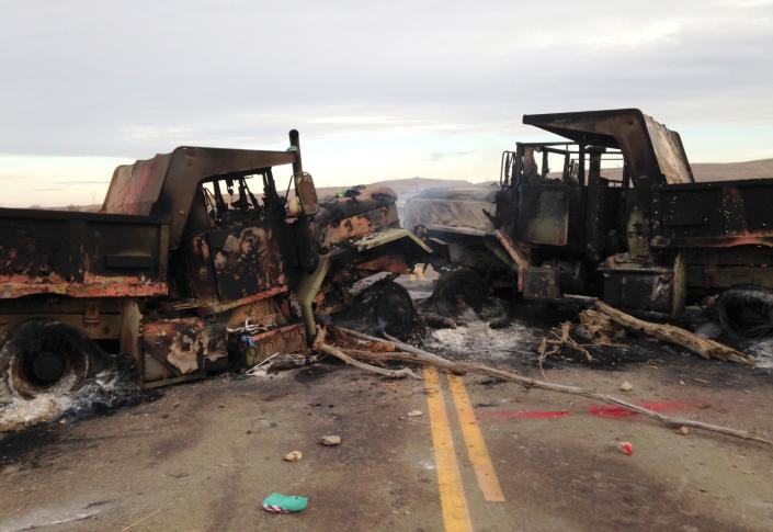 <p>The burned hulks of heavy trucks sit on Highway 1806 near Cannon Ball, N.D., on Friday, Oct. 28, near the spot where protesters of the Dakota Access pipeline were evicted from private property a day earlier. (Photo: James MacPherson/AP) </p>