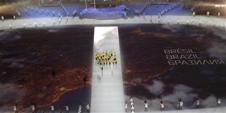 Brazil's flag-bearer Jaqueline Mourao (centre L) holds the national flag as she leads the contingent in the athletes parade during the opening ceremony for the 2014 Sochi Winter Olympics February 7, 2014. REUTERS/Pawel Kopczynski