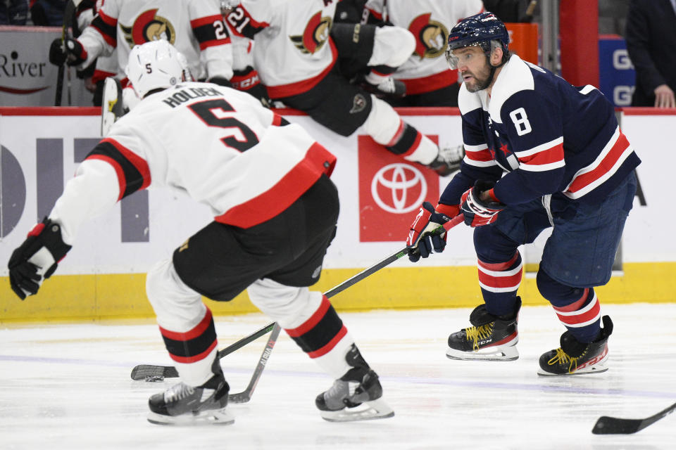 Washington Capitals left wing Alex Ovechkin (8) skates with the puck against Ottawa Senators defenseman Nick Holden (5) during the first period of an NHL hockey game, Saturday, Jan. 22, 2022, in Washington. (AP Photo/Nick Wass)