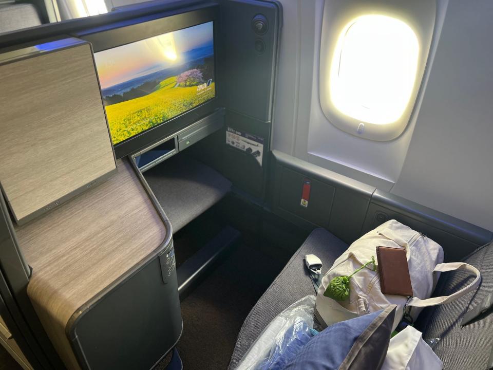 The author's rear-facing seat with a TV and a window to outside the plane.