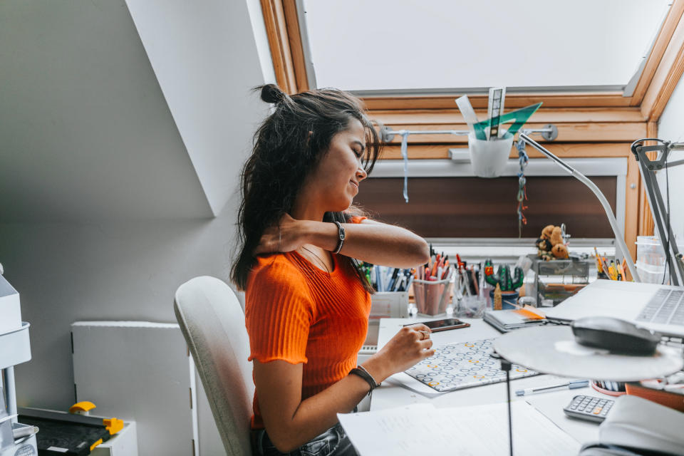 woman feeling stiff sitting at a desk