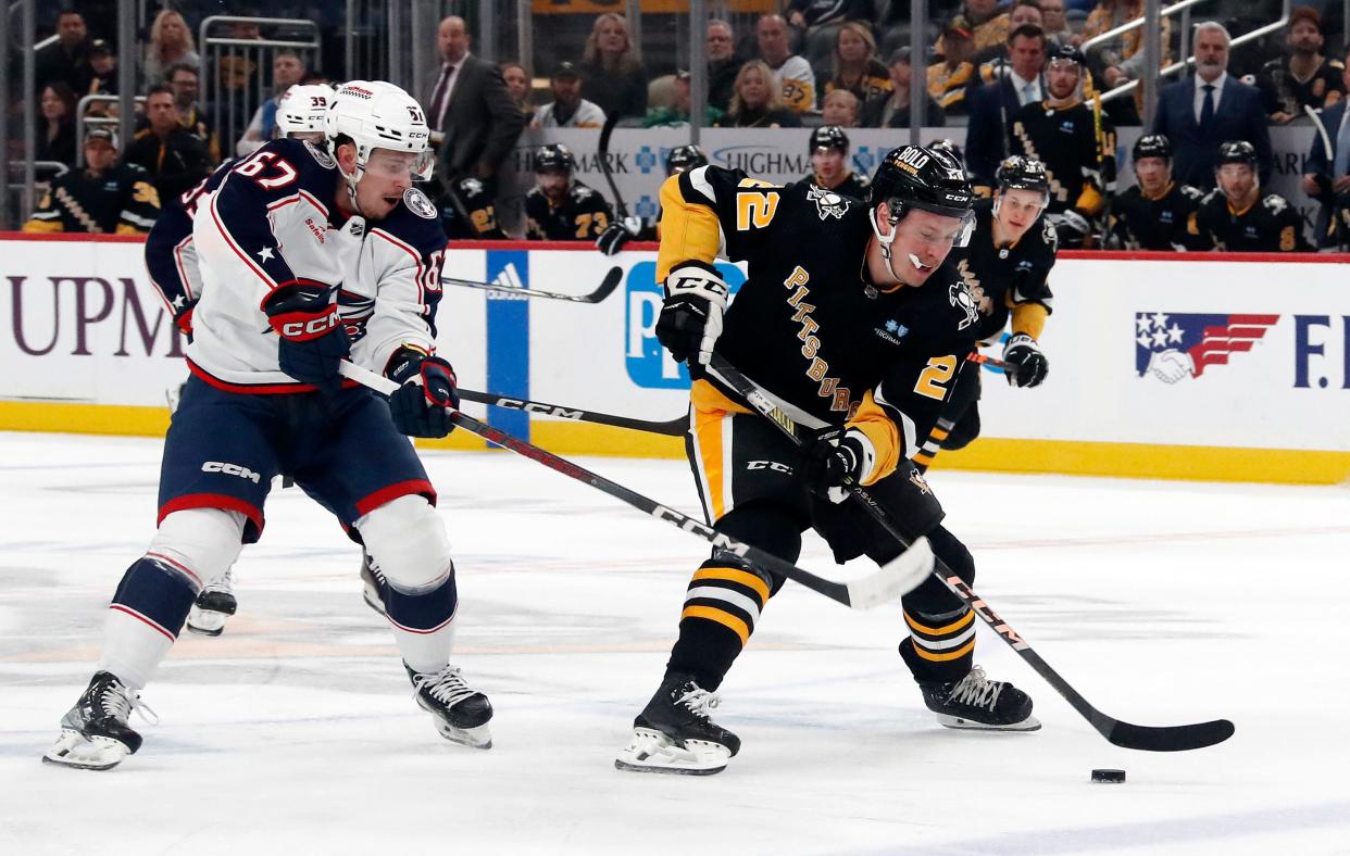 Mar 28, 2024; Pittsburgh, Pennsylvania, USA; Pittsburgh Penguins right wing Sam Poulin (22) skates with the puck ahead of Columbus Blue Jackets left wing James Malatesta (67) during the first period at PPG Paints Arena. Mandatory Credit: Charles LeClaire-USA TODAY Sports