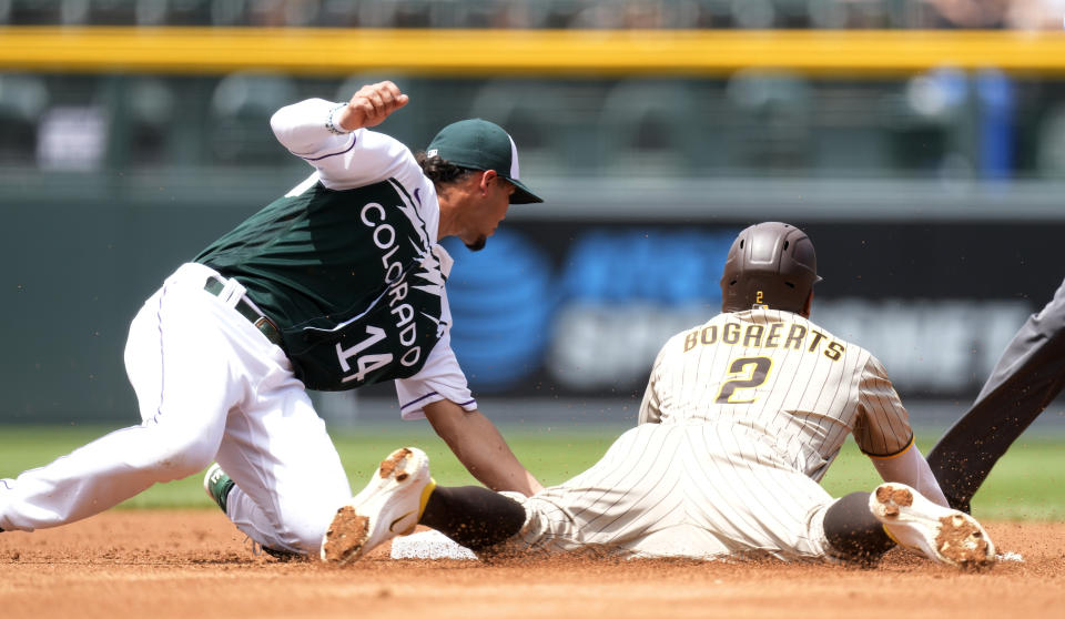 Colorado Rockies' Ezequiel Tovar, left, applies a late tag to San Diego Padres shortstop Xander Bogaerts as he steals second base in the second inning of a baseball game, Wednesday, Aug. 2, 2023, in Denver. (AP Photo/David Zalubowski)