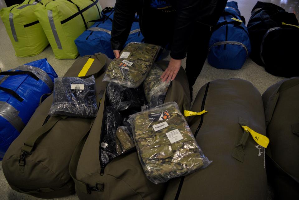 Viktoriia Bobrova opens a bag with camouflage clothing to be sent to Ukrainian soldiers at the Newark Liberty International Airport on Sunday, October 9, 2022 in Newark, New Jersey. 